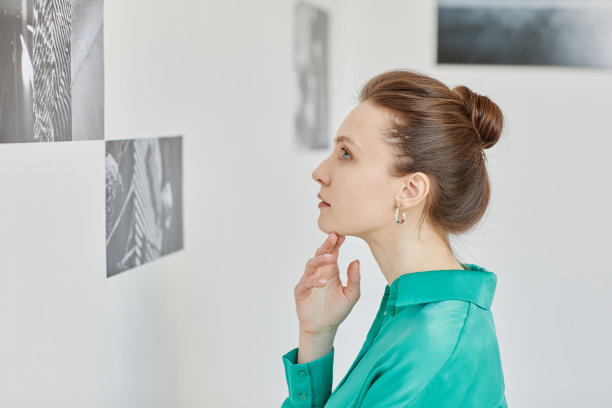 年轻女子参观画廊侧视图图片下载