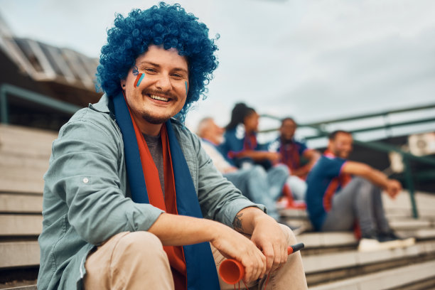 快乐的体育迷等待比赛开始，看着镜头。图片下载