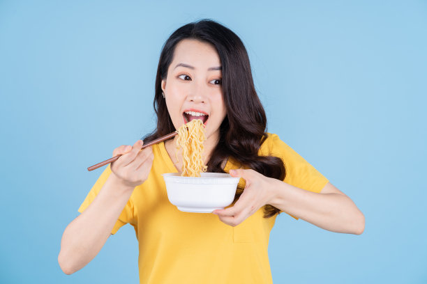 年轻的亚洲女子吃方便面的画面图片下载