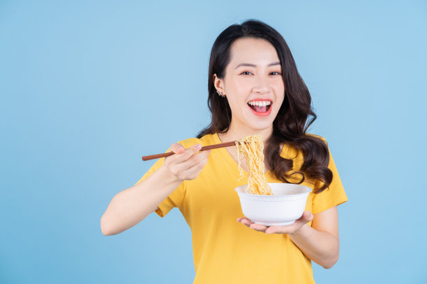 年轻的亚洲女子吃方便面的画面图片下载