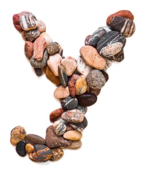 在白色孤立的背景上用光滑的石头刻出的字母。河边的石头上排列着一个字母，细节，特写。有选择性的重点图片下载