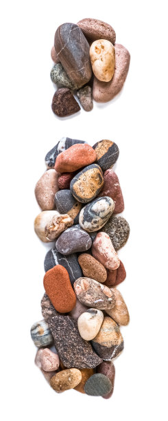 在白色孤立的背景上用光滑的石头刻出的字母。河边的石头上排列着一个字母，细节，特写。有选择性的重点图片下载