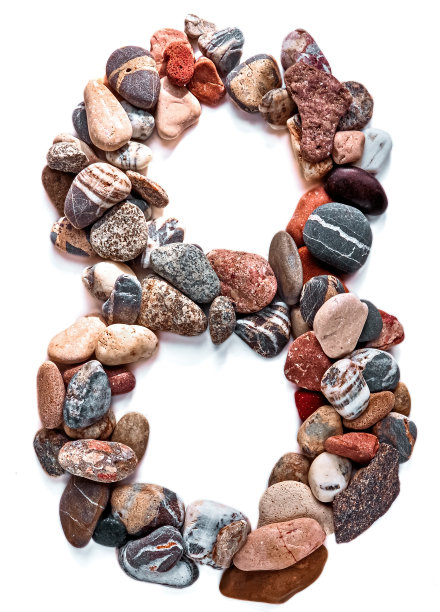 雕像是在白色孤立的背景上用光滑的石头砌成的。河流石头特写，选择性聚焦图片下载