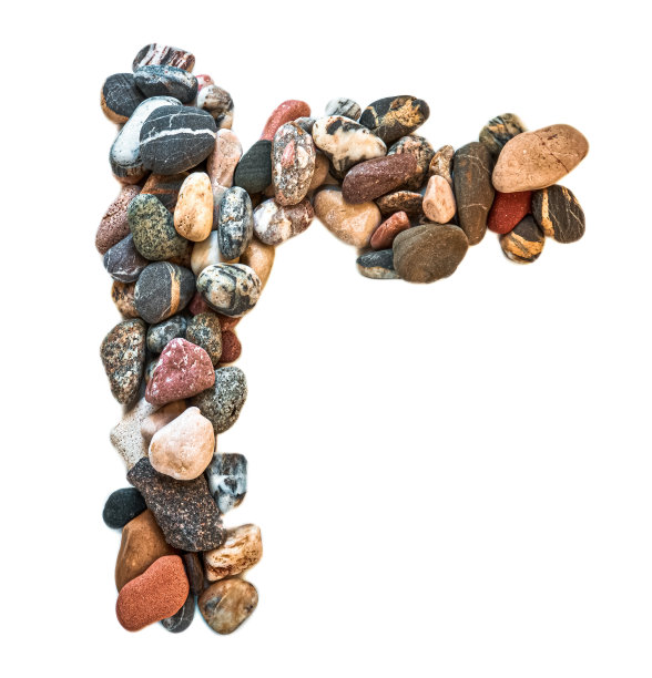 在白色孤立的背景上用光滑的石头刻出的字母。河边的石头上排列着一个字母，细节，特写。有选择性的重点图片下载