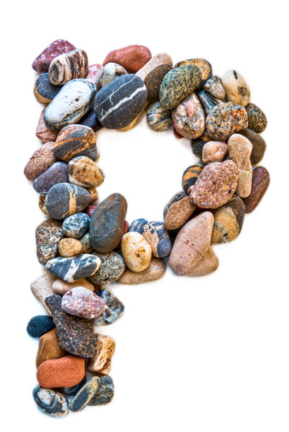 在白色孤立的背景上用光滑的石头刻出的字母。河边的石头上排列着一个字母，细节，特写。有选择性的重点图片下载