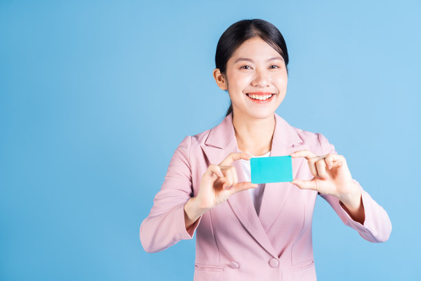 年轻的亚洲妇女持有银行卡，信用卡的背景图片下载