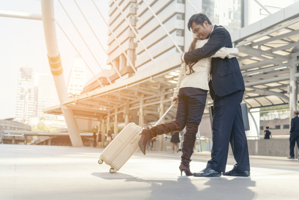 商务情侣带着行李出差。蜜月商务旅行在登机到达终点站拥抱。商务旅行在机场提着旅行箱情侣旅行者图片下载