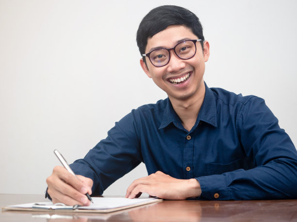 年轻的商人愉快的微笑在公文板上写面试图片下载