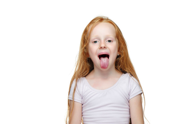 红头发的女孩在白色的背景下伸出舌头图片下载