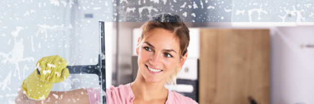 戴着黄手套的女人在擦窗户图片下载