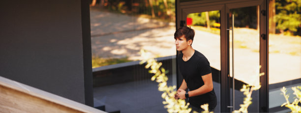 年轻的运动员在寒冷的夏天早晨在公园跑步。图片下载