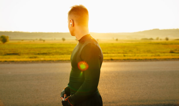 一个运动员回头看这美丽的景色。初升的太阳给了一个生动的色彩和独特的外观图片下载