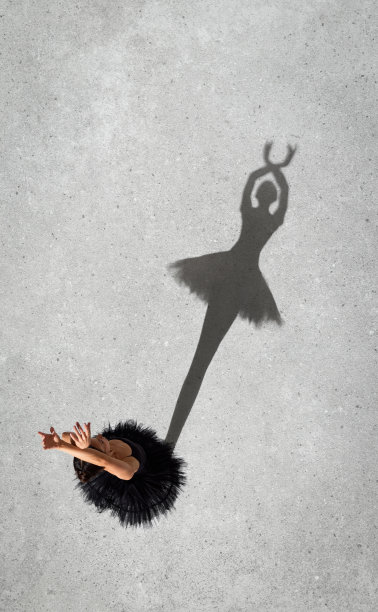 肖像年轻的芭蕾舞女演员在黑色连衣裙表演孤立的灰色墙壁背景。前视图。影子轮廓图片下载