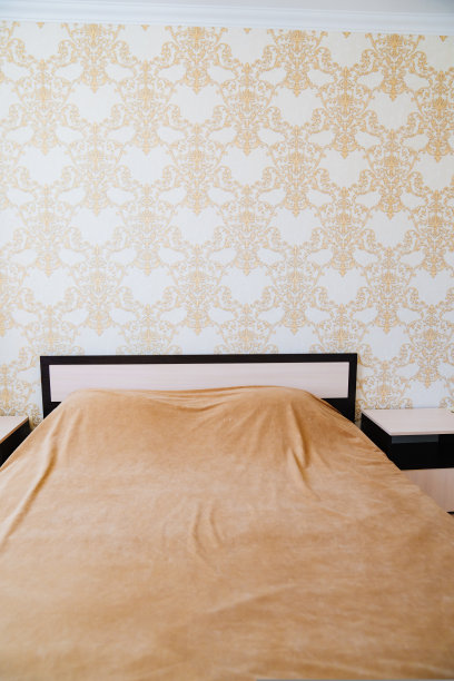 卧室的床上有米色毯子，内饰经典。图片下载