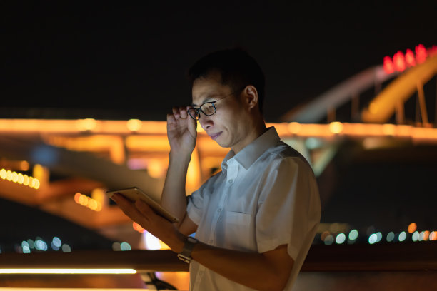 晚上在户外使用平板电脑的男子图片下载