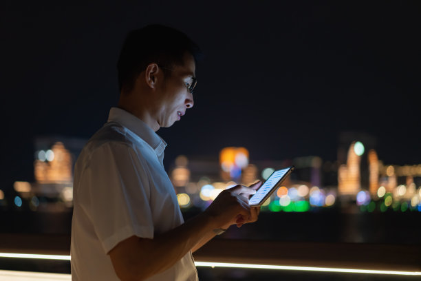 晚上在户外使用平板电脑的男子图片下载