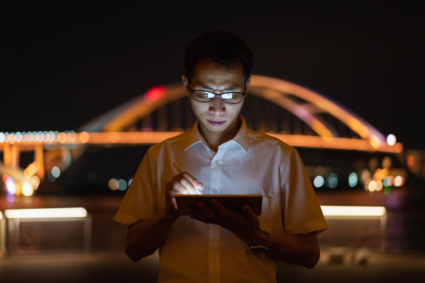 晚上在户外使用平板电脑的男子图片下载