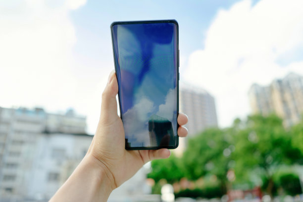 一个人在阳光明媚的日子里用他的手机拍摄街道图片下载