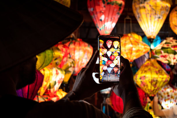 在越南会安，游客正在拍摄点燃的灯图片下载