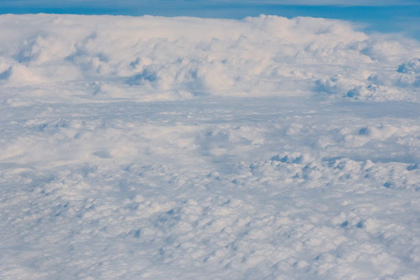 透过飞机的窗户，看到飞机的机翼，白云和蓝天。图片下载