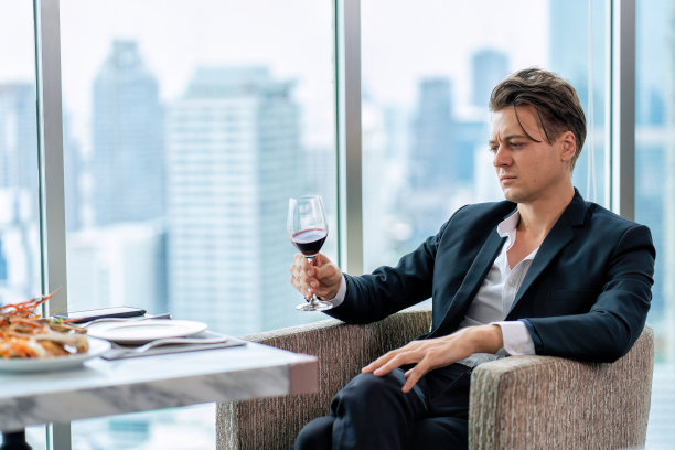 绅士孤独的坐着喝红酒等待朋友图片下载
