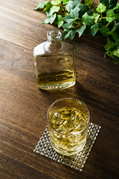 威士忌装在加冰的玻璃杯里，放在木桌上图片下载