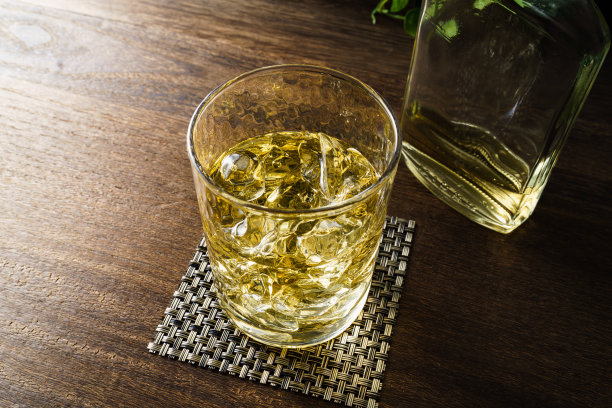 威士忌装在加冰的玻璃杯里，放在木桌上图片下载