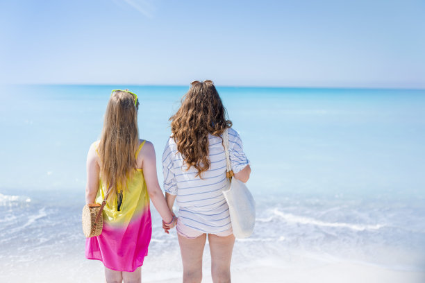 从后面看到的现代母亲和孩子在海滩散步图片下载