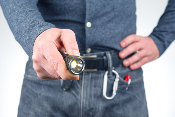 男人手里拿着手电筒。野营和家居用品图片下载