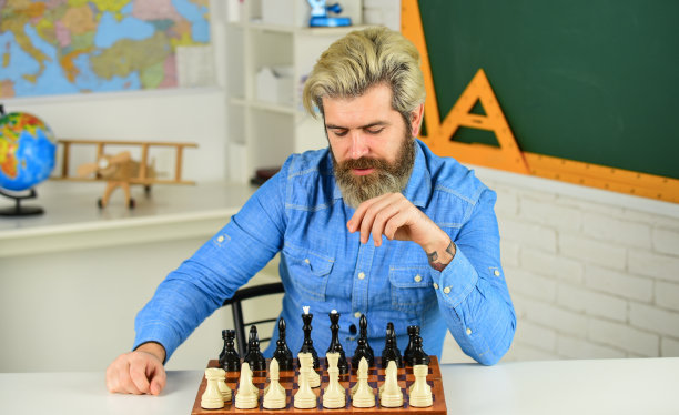 优雅地接受失败。人拿着棋子。专注的人在发展下棋策略。和朋友一起玩棋盘游戏。下棋时下棋。国际象棋棋盘上的棋子图片下载