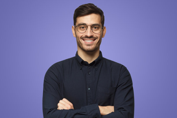 穿着衬衫的年轻男教师的肖像被孤立在紫色的背景上图片下载