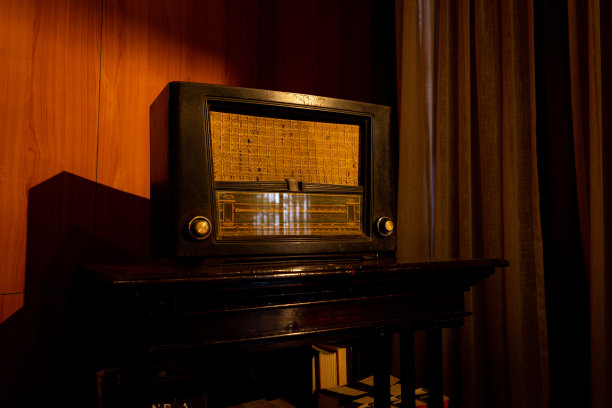 老式老式收音机与音量调谐旋钮和立体声接收器或扬声器和拨号按钮隔离在支架。图片下载