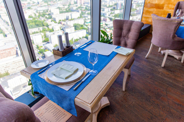 在俯瞰城市的摩天大楼餐厅的两人桌。室内舒适的豪华餐厅与原创设计图片下载