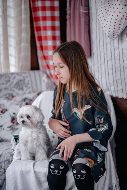 处理过的女孩和宠物的照片。一个小女孩抱着一只小狗。主人对狗狗的爱。图片下载