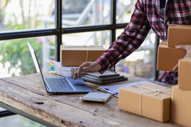 年轻的创业小企业中小企业所有者男性企业家检查网上订单准备，打包装箱，卖给中小企业客户，网上创业想法，在家里销售图片下载