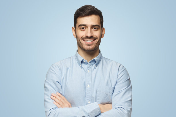 蓝色背景下穿着蓝色衬衫的微笑商人图片下载