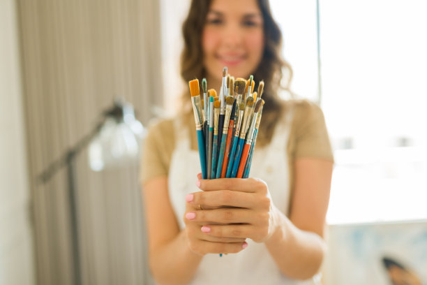 微笑的女艺术家，有很多画笔图片下载