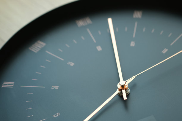 黑色挂钟有金色的指针，看起来优雅而现代。图片下载