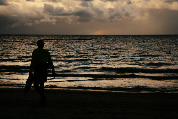 救生员的剪影看着大海和日落图片下载