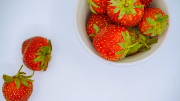 新鲜成熟的美味草莓放在白色的碗里图片下载
