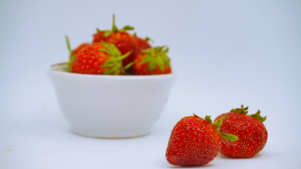 新鲜成熟的美味草莓放在白色的碗里图片下载