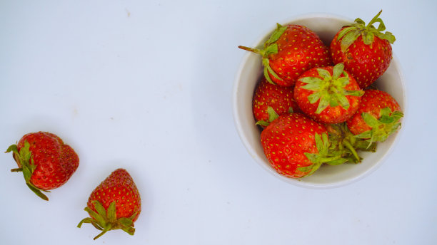 新鲜成熟的美味草莓放在白色的碗里图片下载