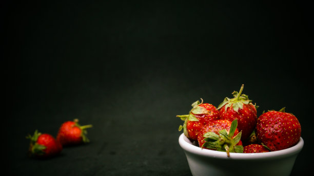 新鲜成熟的美味草莓放在白色的碗里图片下载
