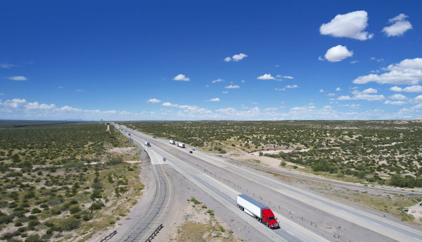 红色和蓝色半卡车行驶在美国德克萨斯州10号州际公路上——鸟瞰图图片下载