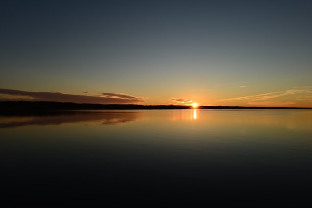 在阳光灿烂的蓝天上反射水面的秋天日落景观图片下载