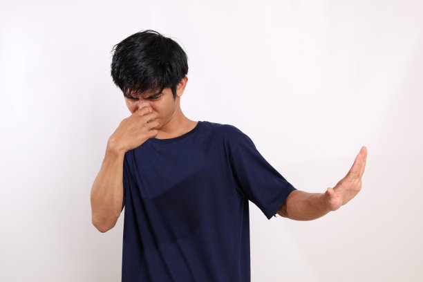 亚洲年轻人站着捂着鼻子。坏气味的概念。孤立在白色背景中图片下载