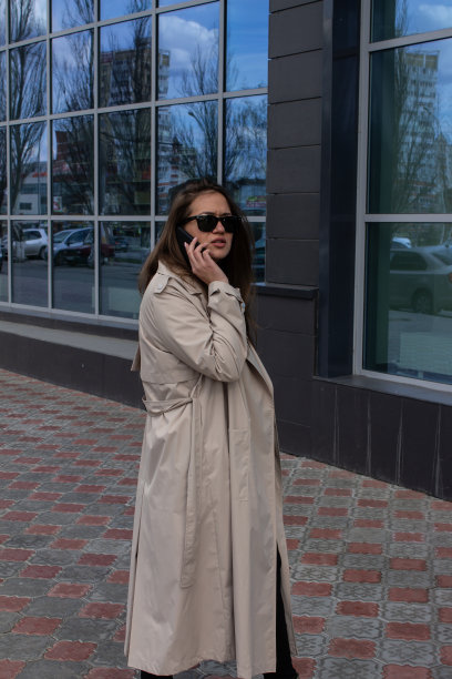 年轻的棕色头发美丽的女孩，绿色的眼睛和一个轻壕的背景建筑和商业中心在城市图片下载