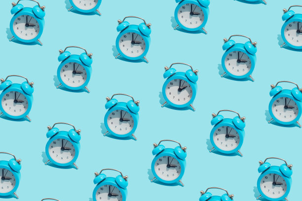 蓝色复古闹钟的无缝模式显示3点和一个显示2点。将时钟从夏季时间改为冬季时间。把时钟的指针拨回秋天。图片下载