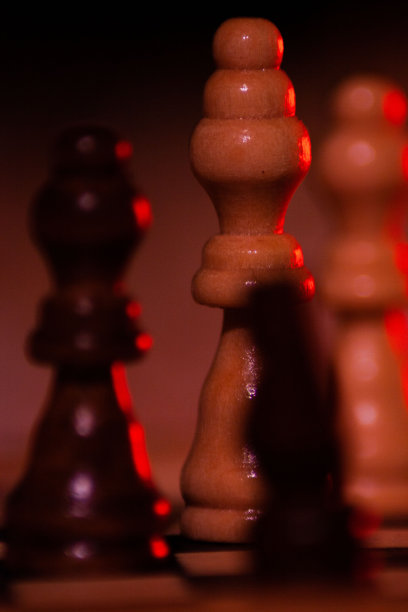 国际象棋棋子在红灯下的垂直镜头图片下载