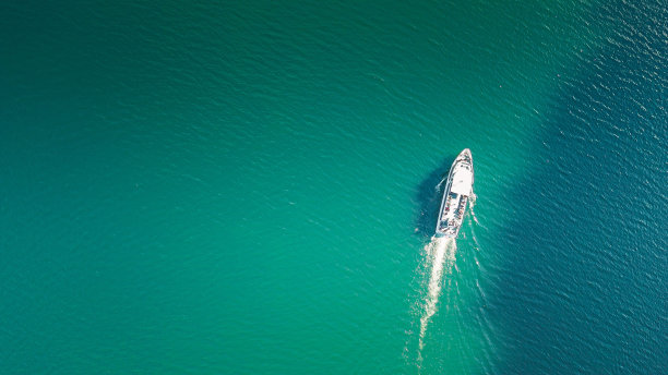 俯瞰在平静的蓝绿色大海上航行的船只图片下载